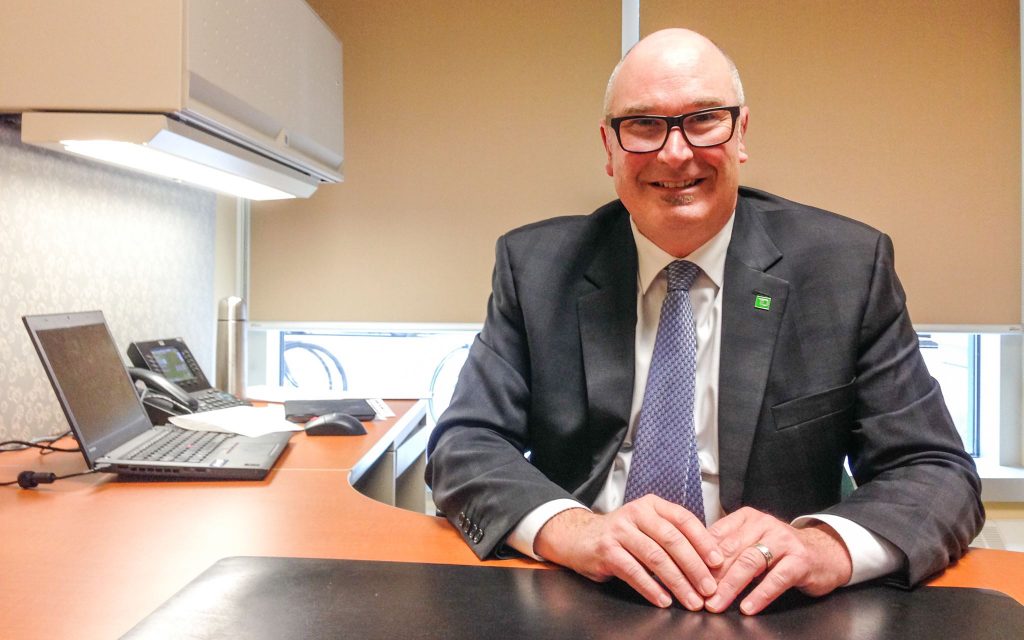 Richard Parks sits at a desk, smiling.